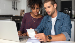 Couple sitting in kitchen looking at bills