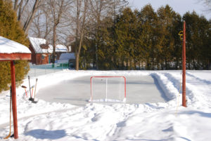 Backyard skating rink at home with snow and hockey net